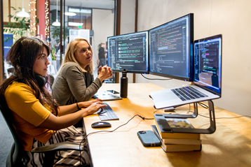 صورة لأشخاص أعمال عامين على أجهزة كمبيوتر في إعداد مكتب.