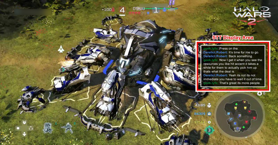 Základna v Halo Wars 2. Na pravé straně obrazovky se chat od hráčů zobrazuje v černém rámečku. Toto pole je obklopené červeným polem, které zvýrazní, že se jedná o oblast převodu řeči na text.
