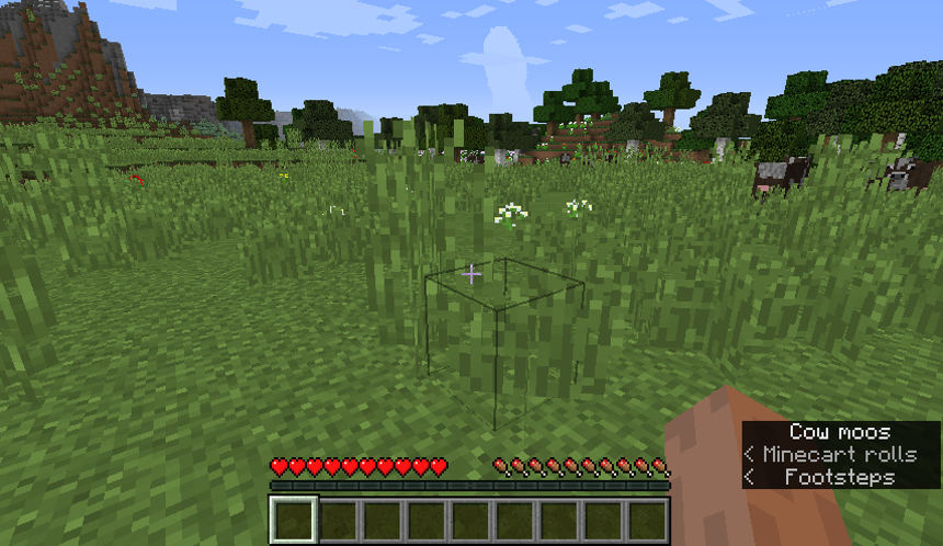 Snímek obrazovky z hry Minecraft zobrazující směrové šipky a titulky environmentálních zvuků.