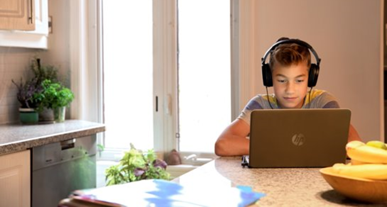 Abbildung eines Schülers, der mit einem persönlichen PC und Headset arbeitet.