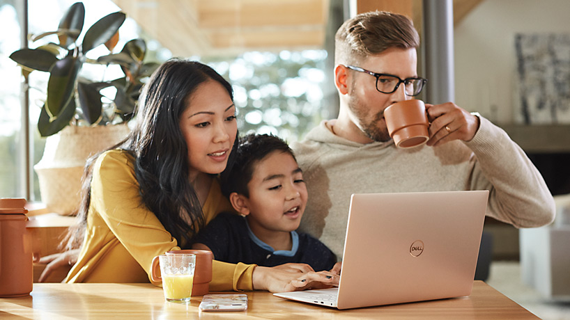 Photo of parents and child using a laptop.