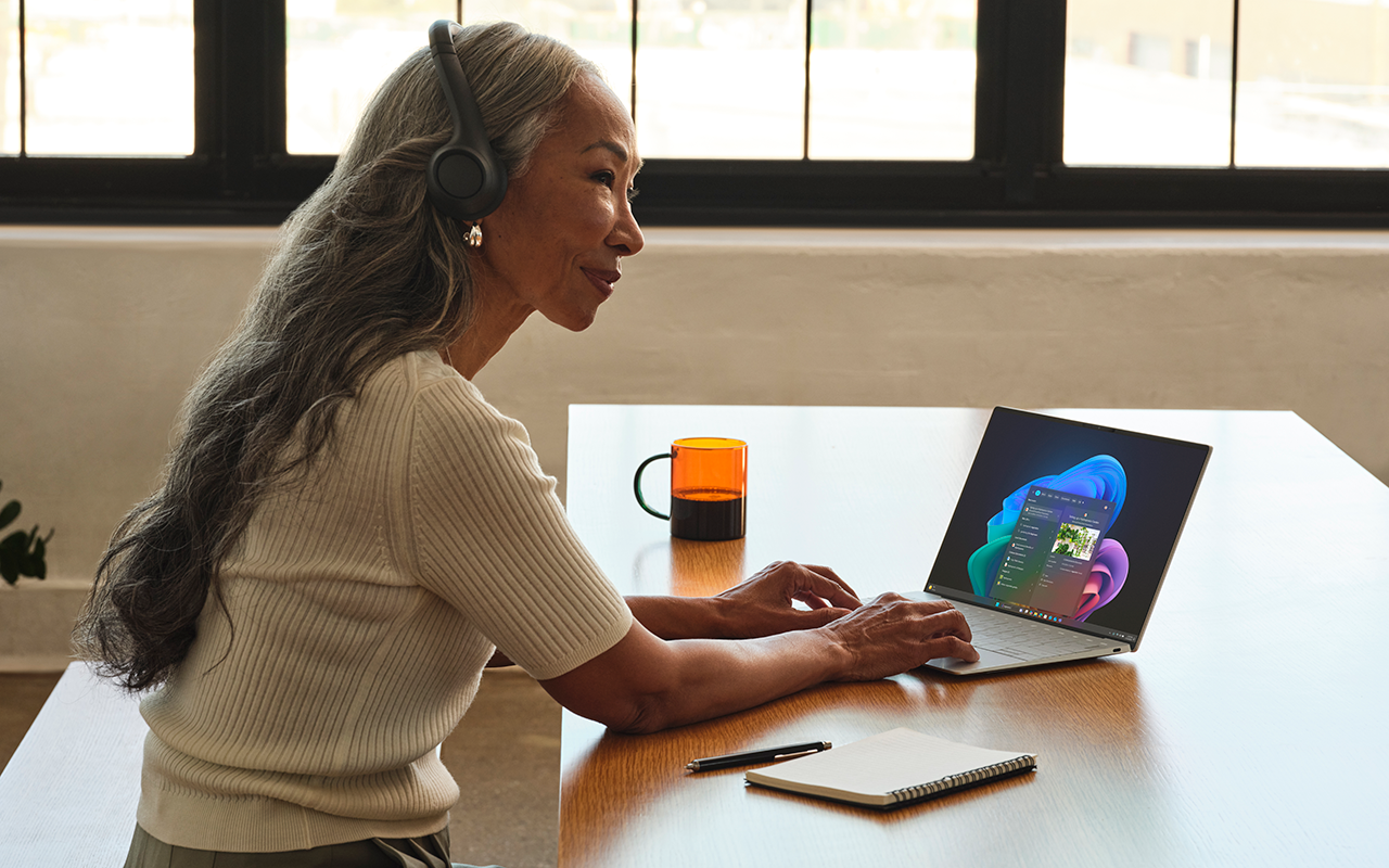 Fotografie einer Frau, die ein Headset trägt, während sie an einem Copilot+-PC arbeitet.