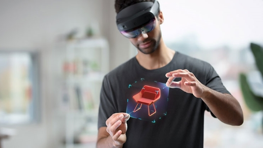 Photo of a HoloLens 2 user manipulating the hologram of a chair.