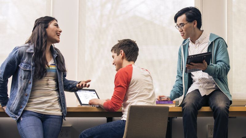 Photo of three students working together.