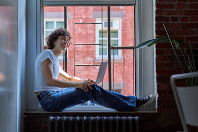 Screenshot of person working on a laptop.