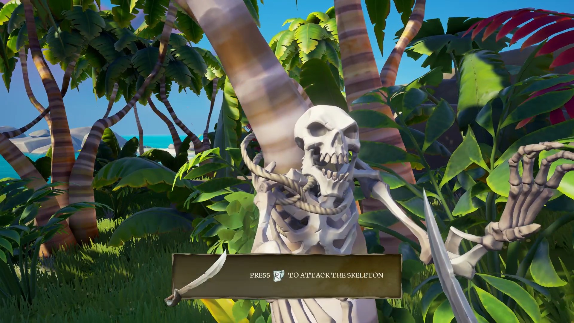 Screenshot of Sea of Thieves game showing text that reads "Press RT to attach the skeleton" with RT resembling a button on game controller. A white skeleton also appears behind the text and it is tied to a tree trunk in a beach like setting.