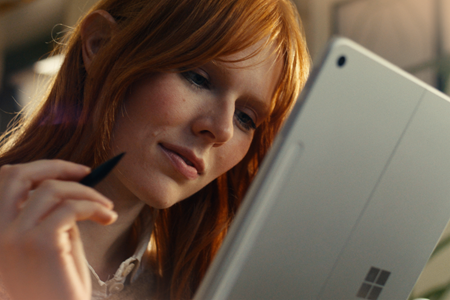 Screenshot of a person looking at a tablet.