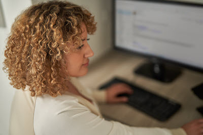 Screenshot of a person working on a laptop.