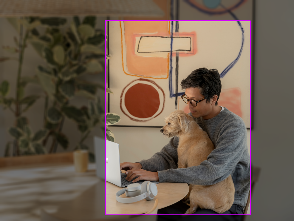 Photo of a man with a dog at a table. A 0.75 ratio bounding box is drawn.