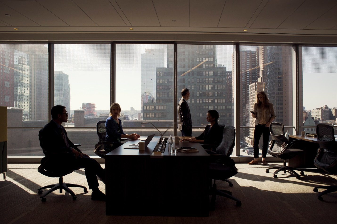 A photograph showing three people in meeting.