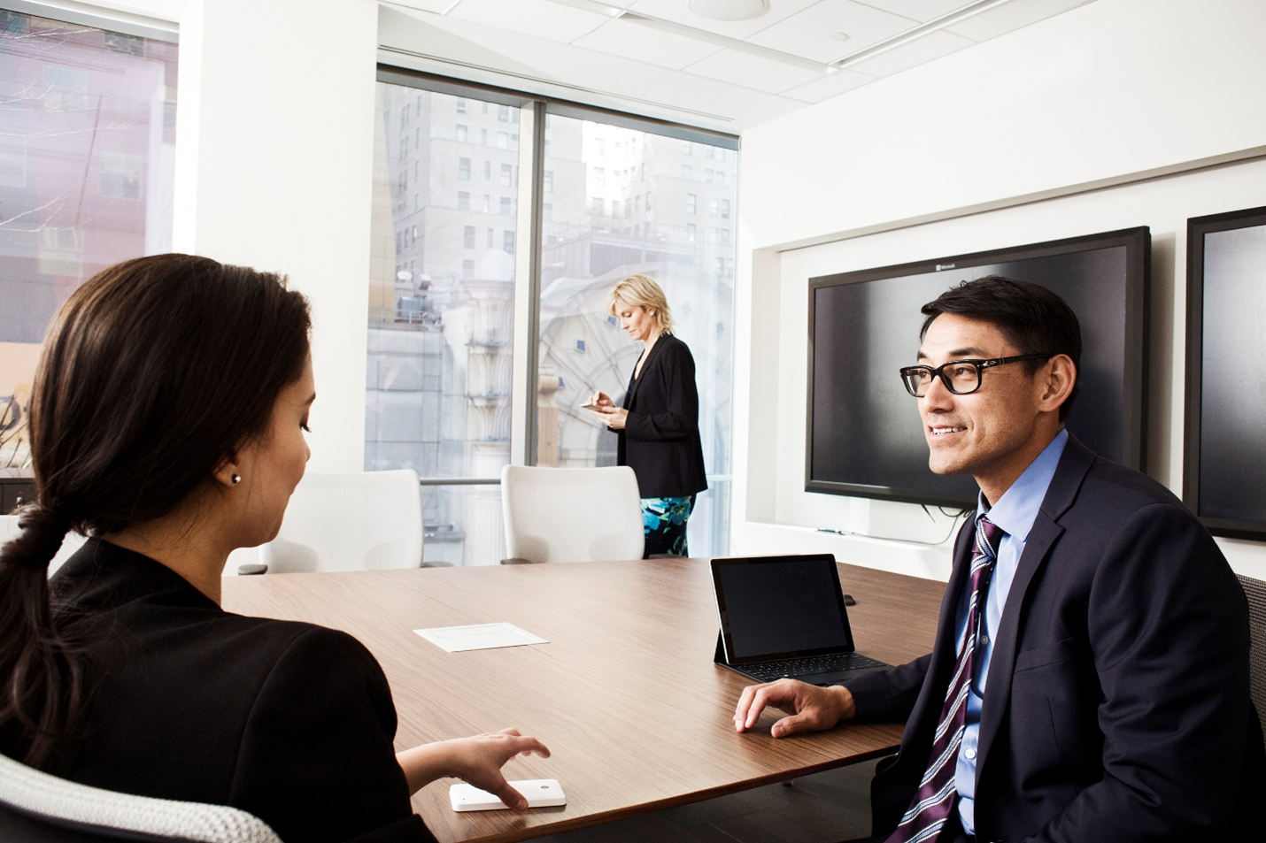 A photograph showing three people in meeting.