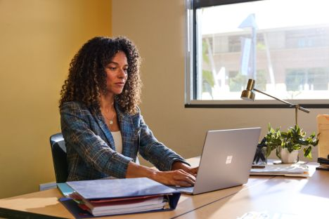 Photo of an educator at a desk using a laptop.