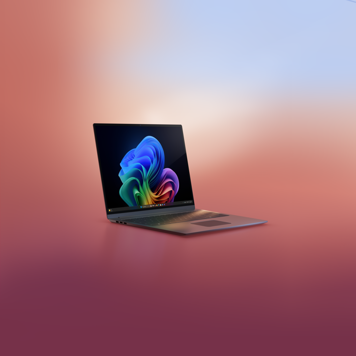 A photograph of a gray laptop showing the Copilot+ PC bloom on the screen.