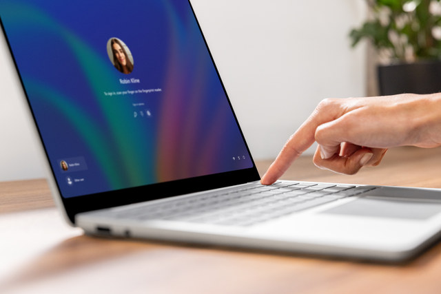 A photograph of a business person providing biometric information via their fingerprint for Windows Hello for Business on a Surface device.