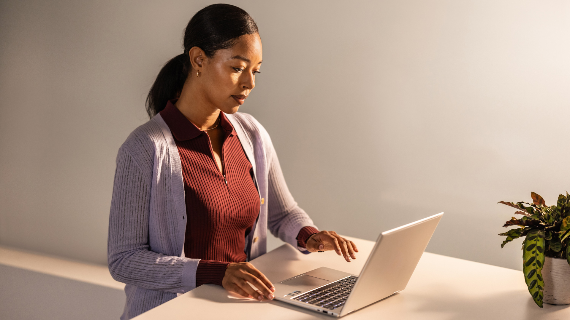 Photo of an enterprise knowledge worker at a desk reviewing documents on a laptop.