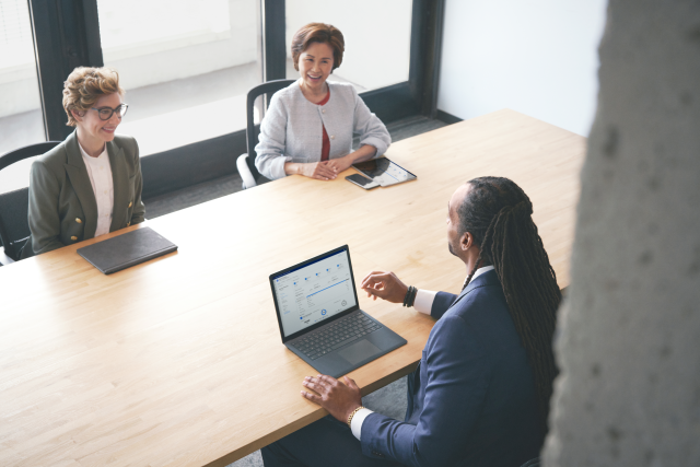 A photograph of investment advisor meeting with customers in a modern office discussing financial data during an investment meeting.