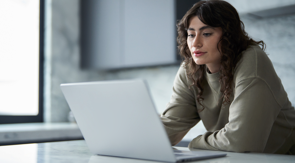 A photo of an educator working on a laptop in a remote environment.