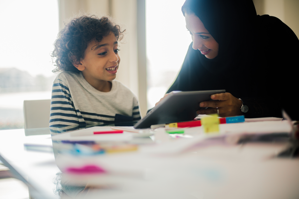 A photo of a K-12 student using a tablet for remote learning.