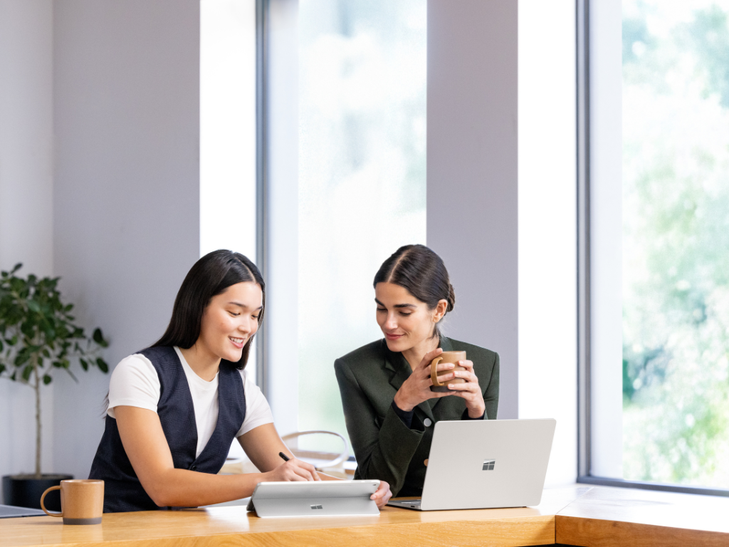 Photo of two users collaborating on Surface devices.