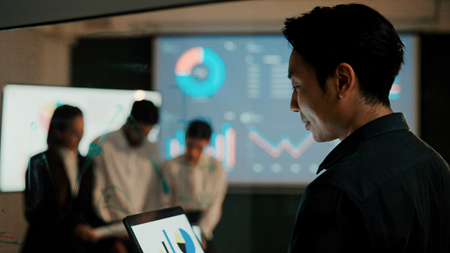 Screenshot of a business person looking at a device.