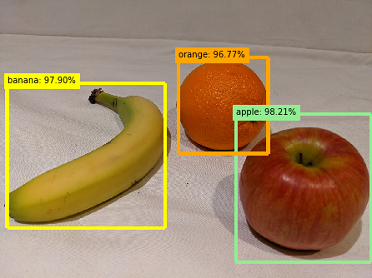 A banana, and orange, and an apple, each indicated by a bounding box and a probability score