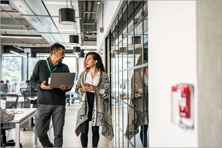 Screenshot of two people walking through an office environment.
