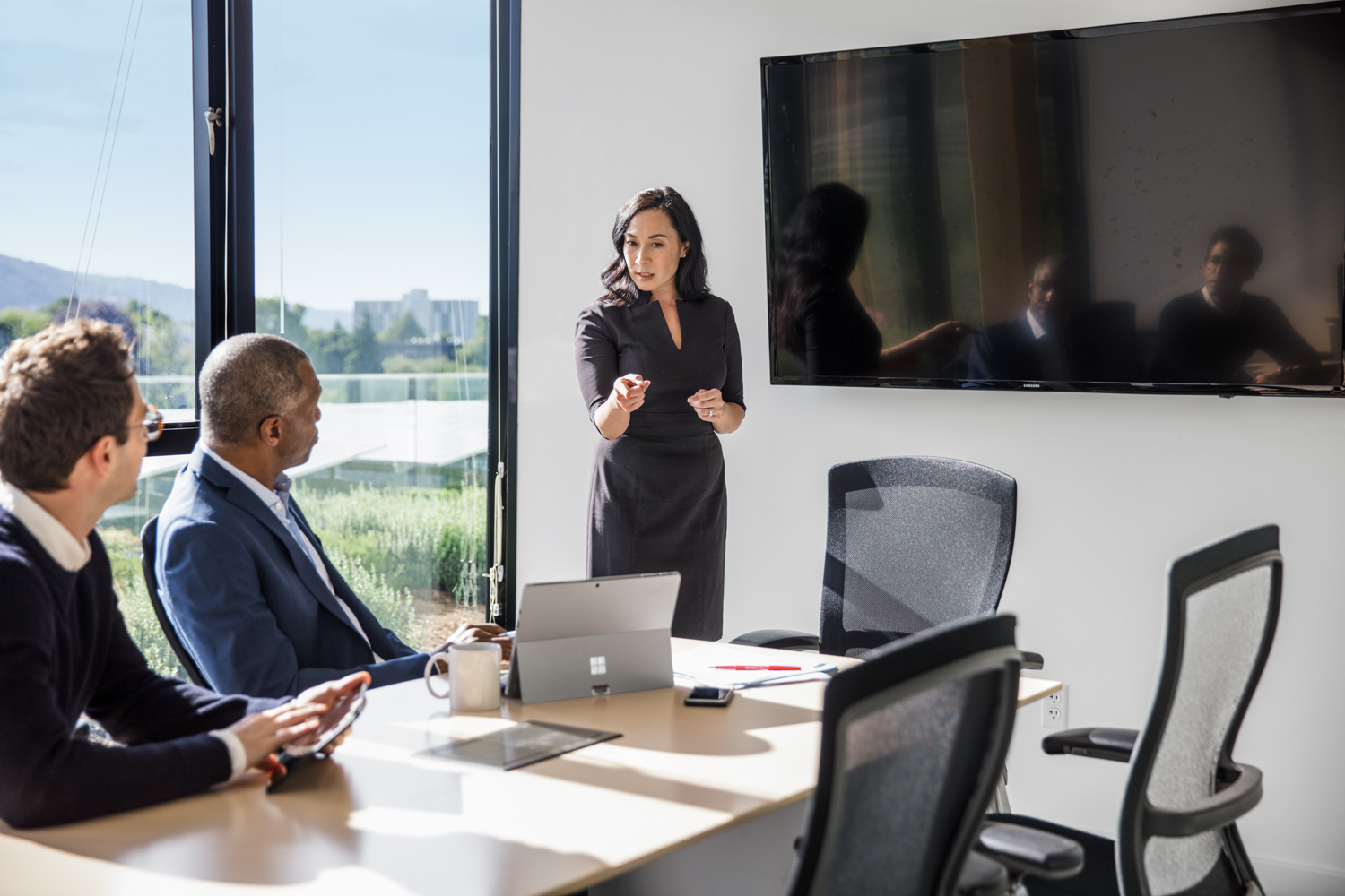 Les employés de bureau se réunissent dans une petite salle de conférence. L'un d'eux fait une présentation.