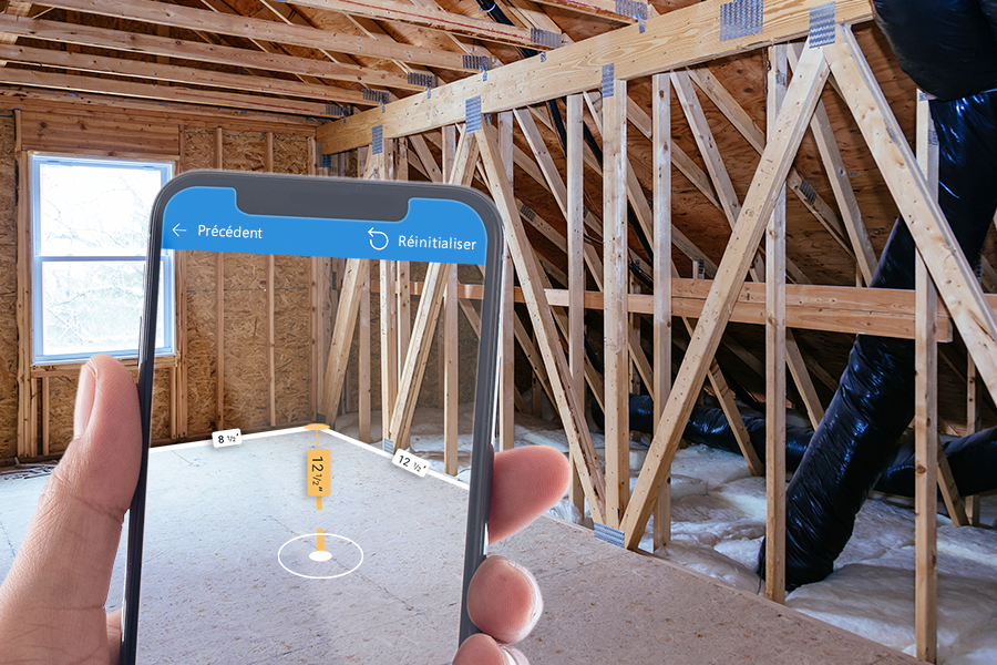 Une photo d’un écran de téléphone qui affiche les dimensions superposées sur un coin d’une pièce en construction.