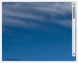 Une image d’une montagne zoomée à tel point que seul le ciel bleu et les nuages dans le coin supérieur gauche de l’image sont visibles.