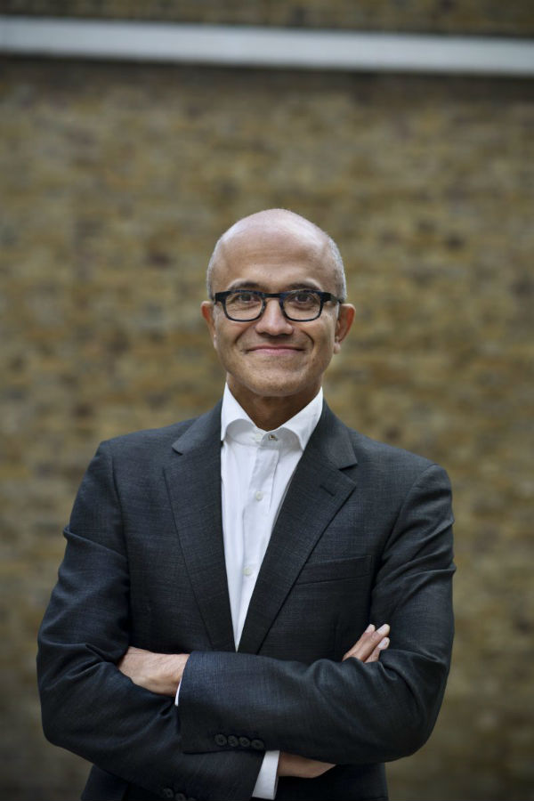 Satya Nadella állva, mosolyogva