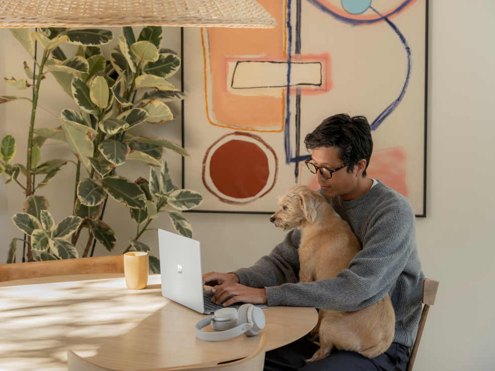 Photo of a man with a dog at a table.