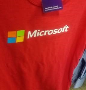 Kemeja merah dengan label dan logo Microsoft di atasnya