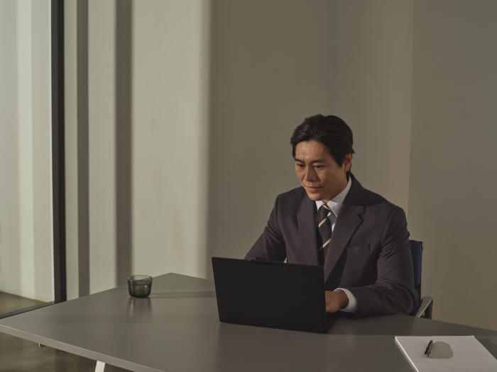 Foto perangkat Windows 11 Pro yang digunakan oleh seorang pria dalam suasana ekspresif, berada di ruang kantor pribadi.