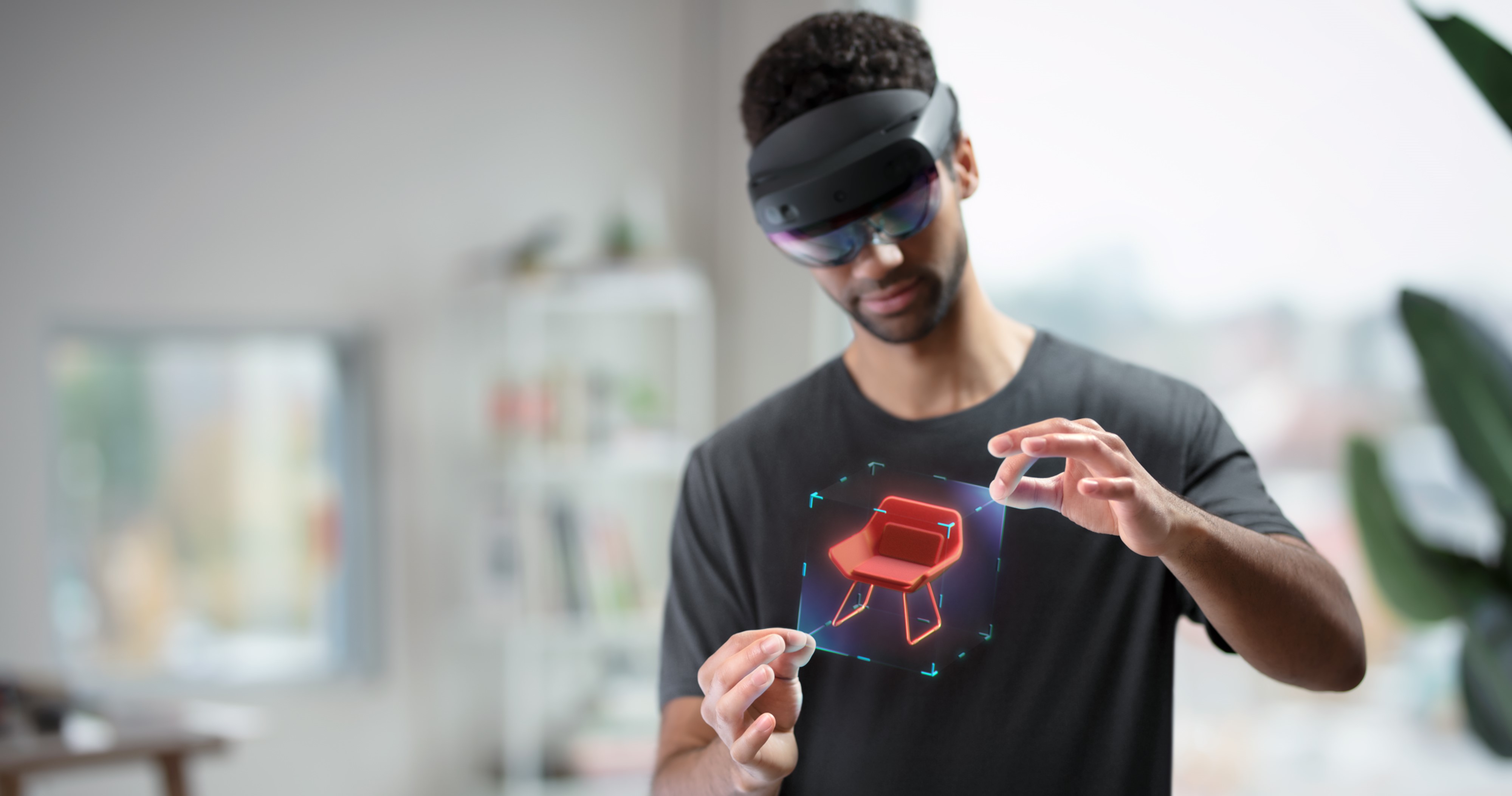 Gambar pengguna yang mengenakan HoloLens dan memanipulasi hologram dengan gerakan tangan