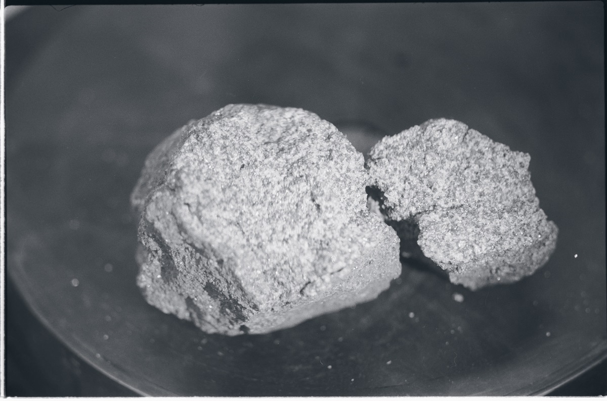 A photo of two pieces of basalt rock on a flat surface.