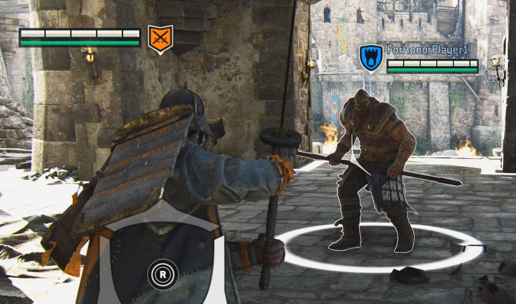 Un giocatore viene avvicinato da un nemico nel gioco For Honor. Il giocatore ha un simbolo di un castello sopra la loro testa. Il simbolo ha un contorno nero anche delineato in bianco. Il nemico ha un simbolo rosso sopra la testa con spade incrociate. Tale simbolo è anche delineato in nero e poi in bianco.