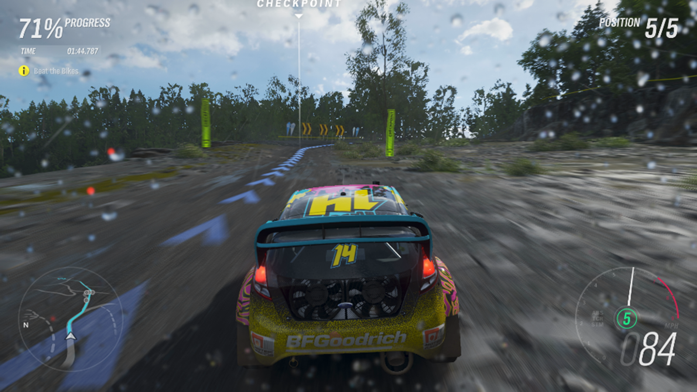 Un'auto da corsa che guida su una strada sporcizia in Forza Horizon 4. La mini-mappa in basso a sinistra ha una linea blu che indica il percorso che il giocatore deve guidare, e il tachimetro in basso a destra usa rosso e verde per indicare l'ingranaggio corrente e velocità elevate.