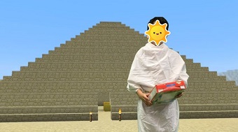 Schermafbeelding van een leerling/student die een groen scherm gebruikt om zichzelf op te nemen in een video met de achtergrond van een piramide in Minecraft: Education Edition.