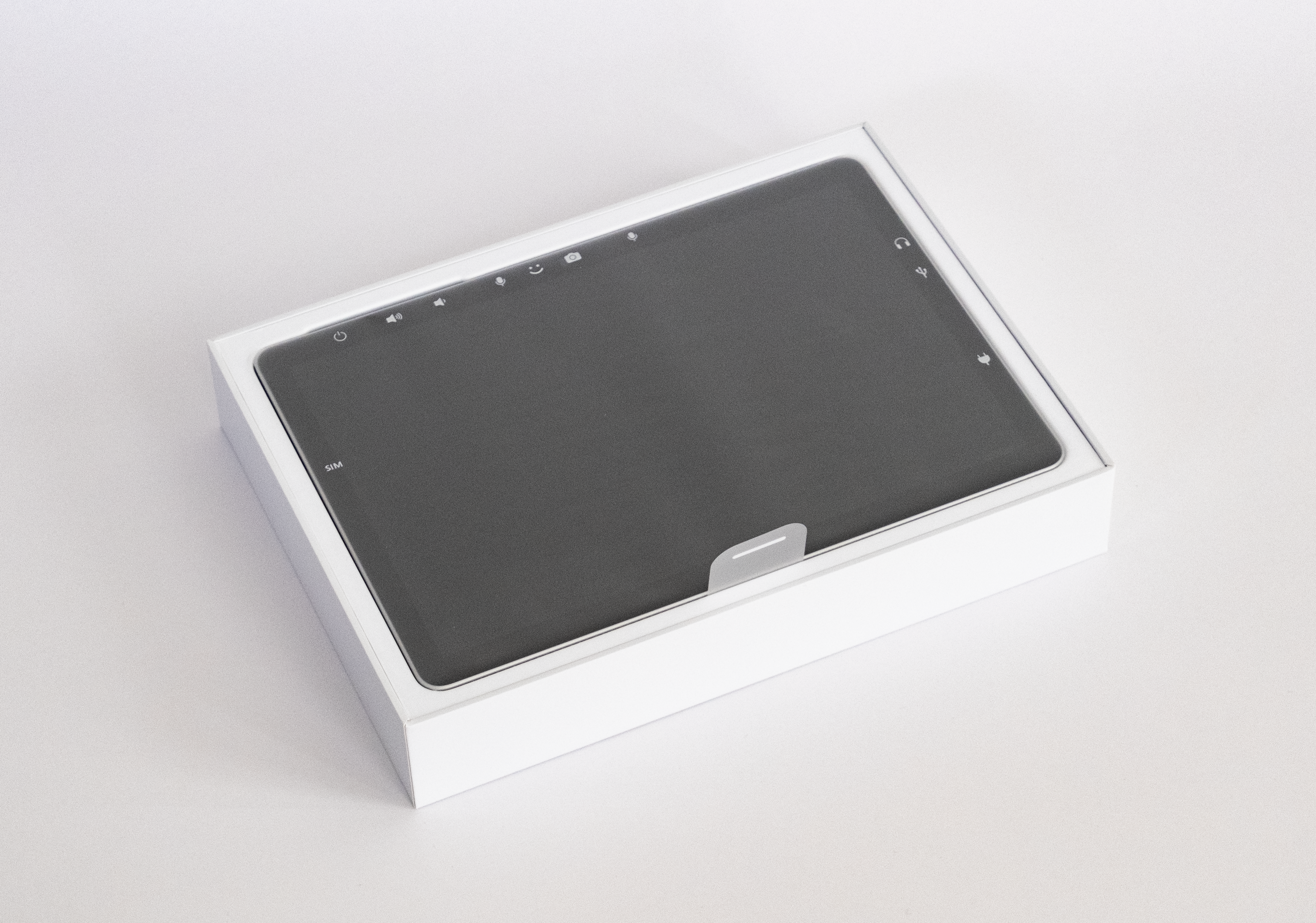 Uma imagem da embalagem para um dispositivo Microsoft Surface. Uma aba de puxar para remover o dispositivo está visível. 