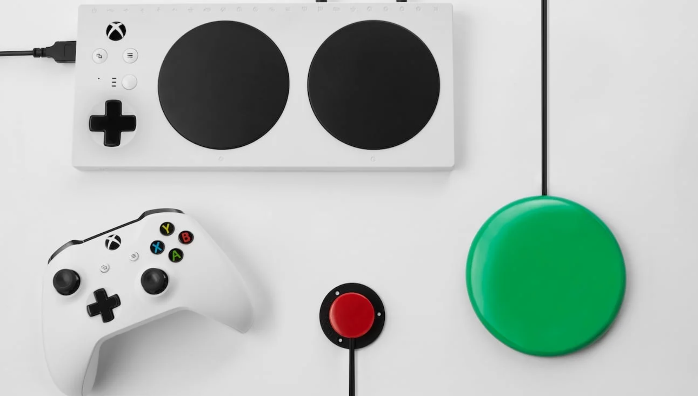 Uma coleção de controladores, incluindo o Controle Adaptável do Xbox, um pequeno comutador vermelho, um grande comutador verde e um Controlador Xbox padrão.