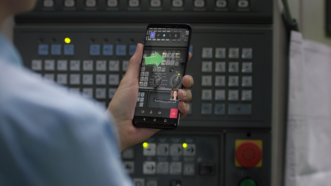 Imagem de uma pessoa usando o Remote Assist em um celular Android com uma seta verde representando uma anotação de realidade misturada.
