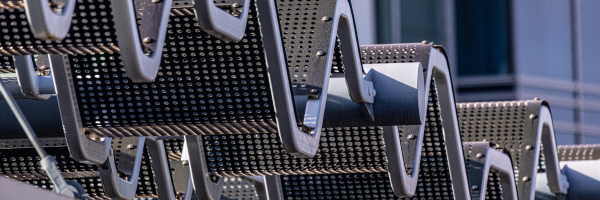 An abstract photo of a wavy metal roof shining in the sunlight.