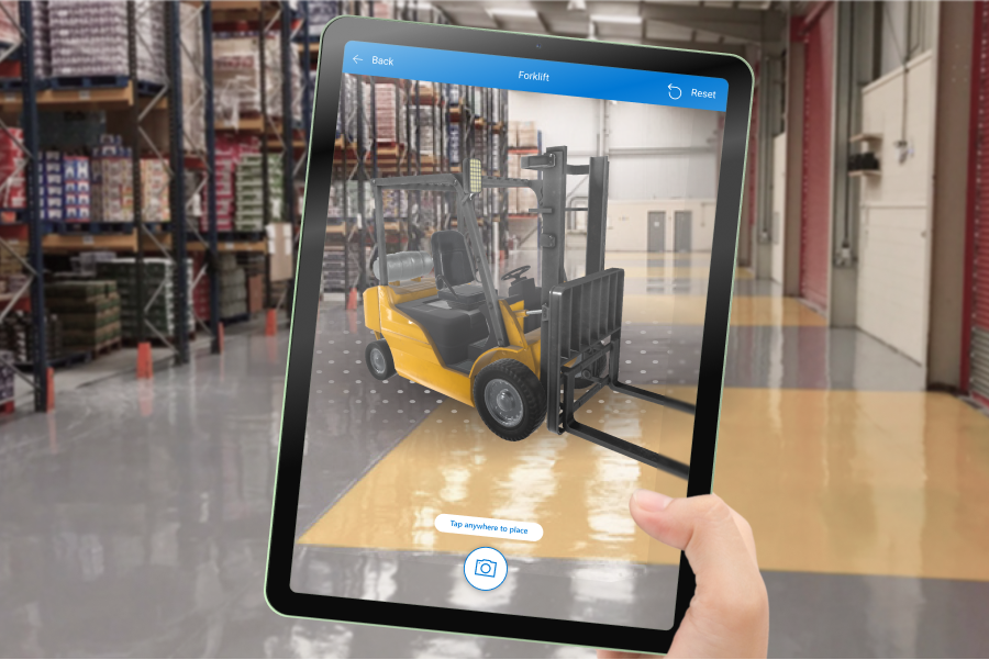 Tablet ekranının fotoğrafı, ambarın iç görünümüne yerleştirilmiş bir forkliftin 3B modelini gösterir.