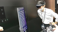 Photo of a construction worker using HoloLens to examine a digital blueprint.