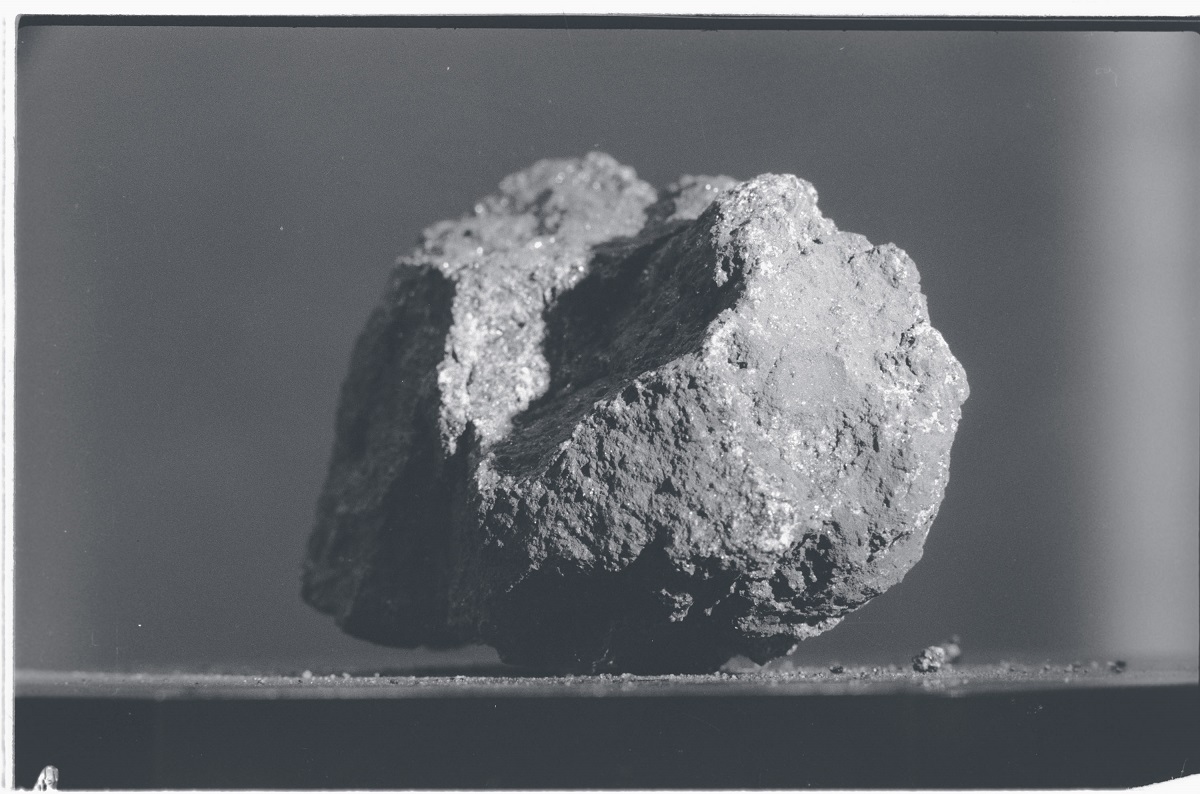 A photo of a piece of basalt rock on a flat surface.